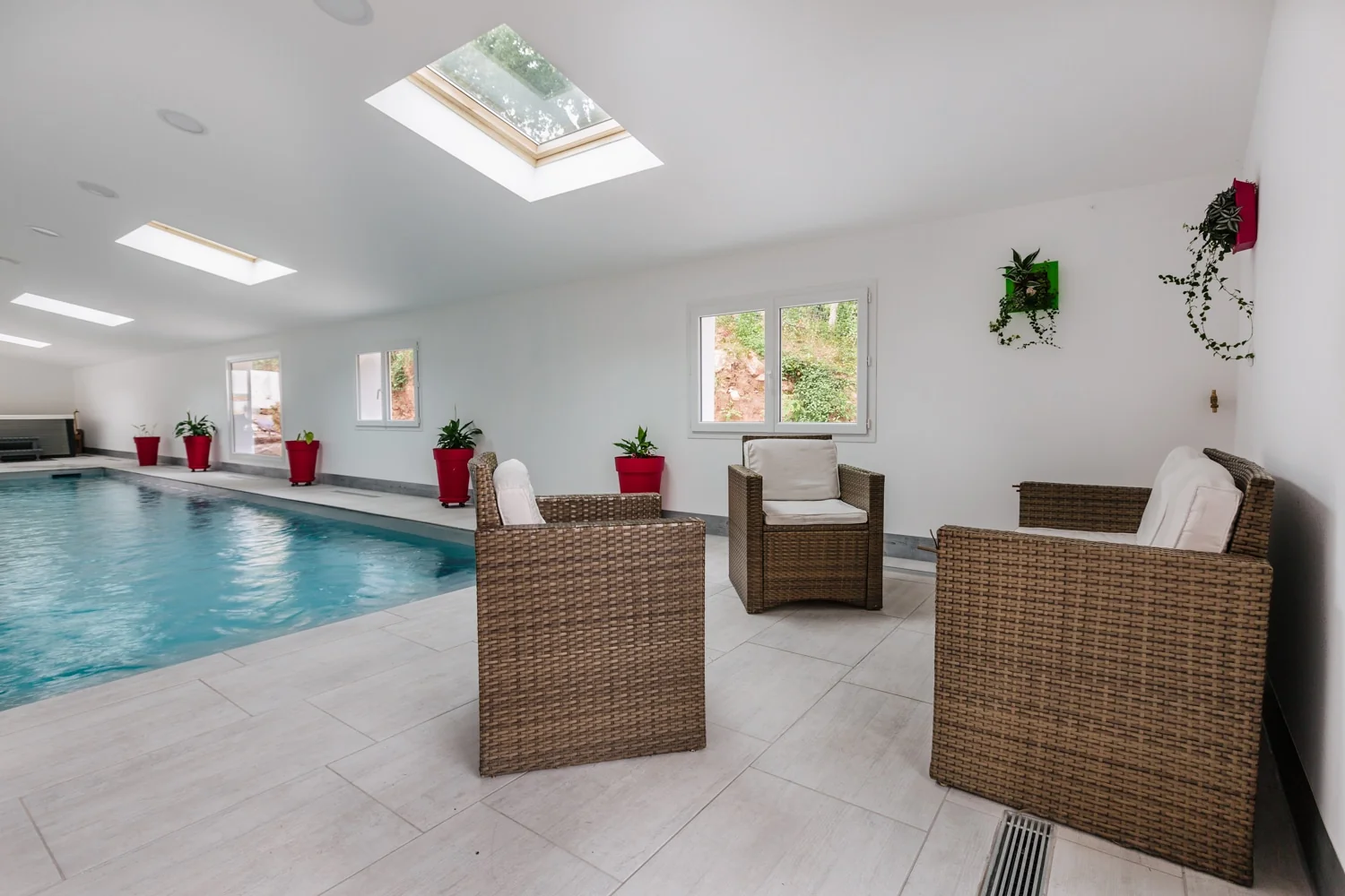 Piscine intérieure dans une pièce lumineuse avec un espace salon