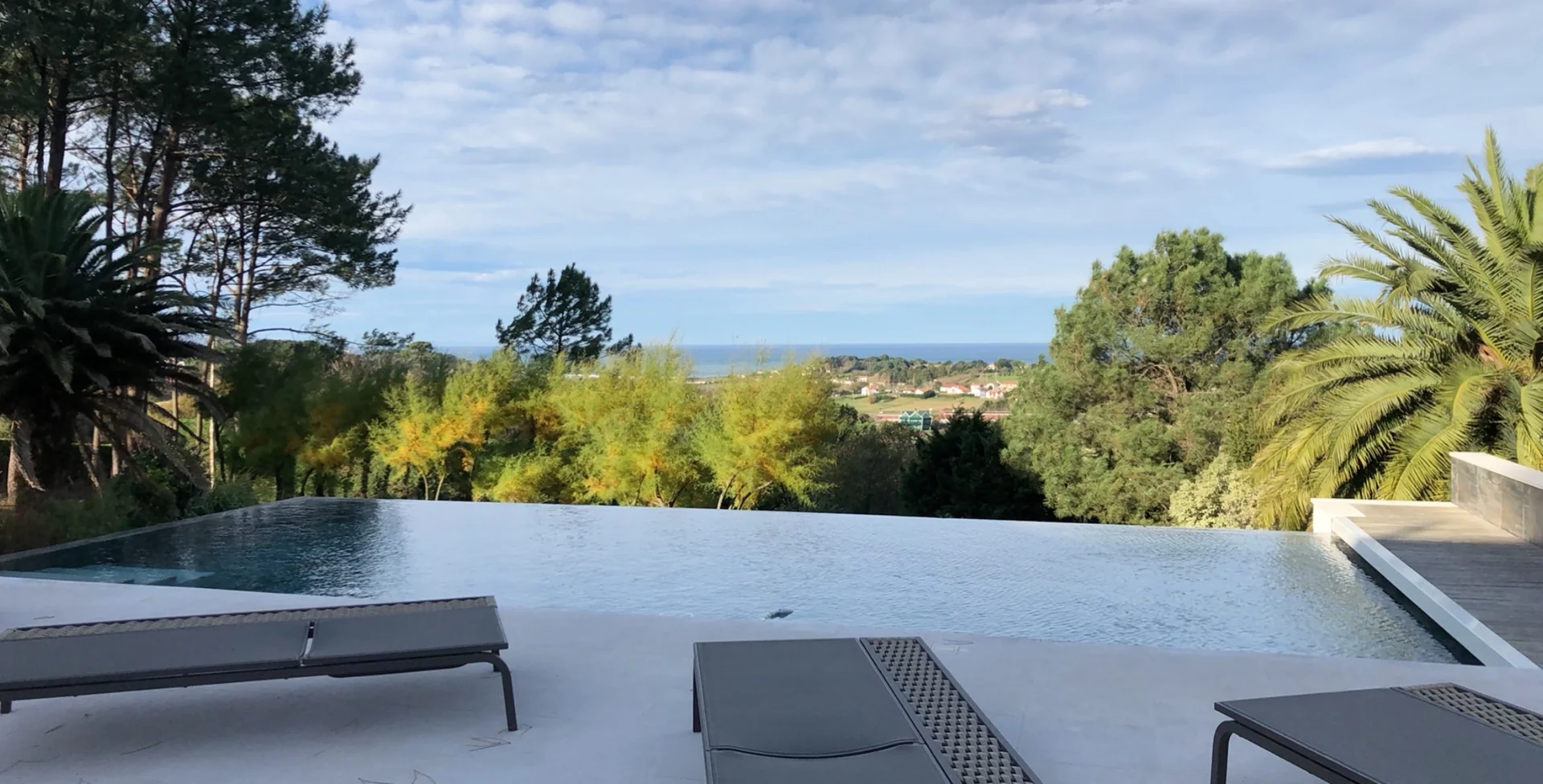 Bassin à débordement avec membrane claire et vue sur les arbres, avant mise en eau