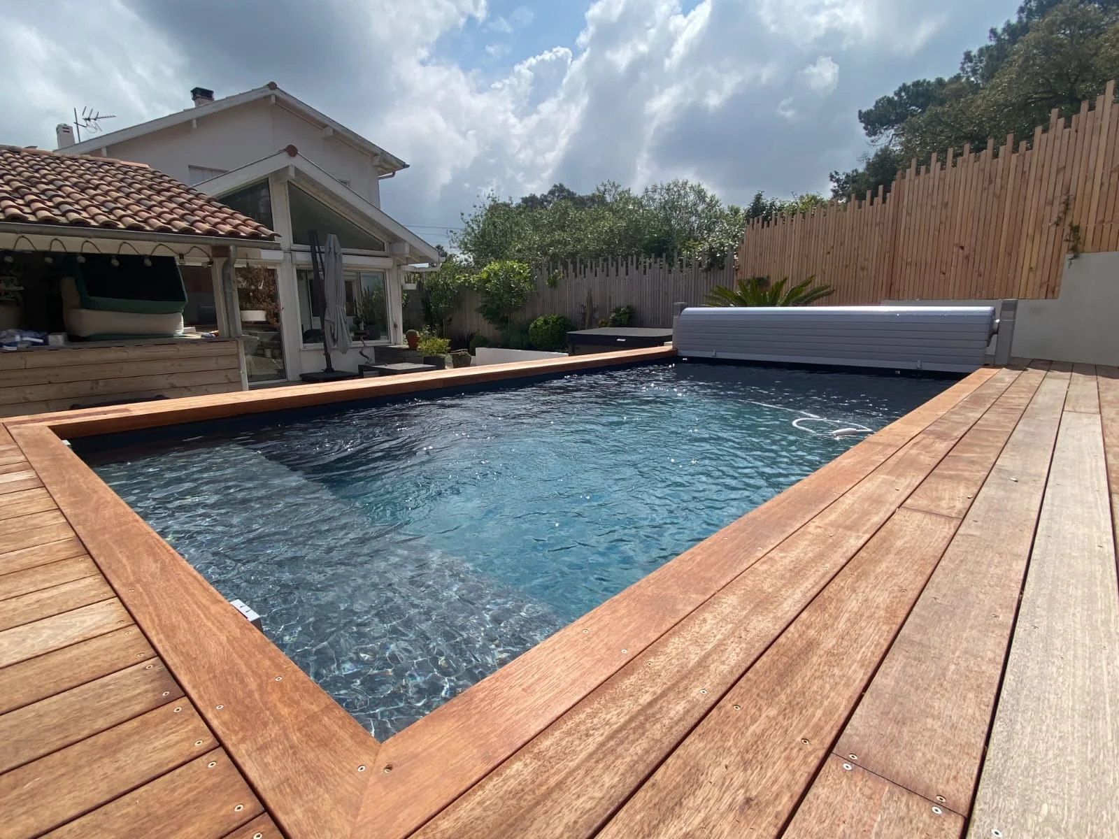 Piscine avec terrasse en bois et assises