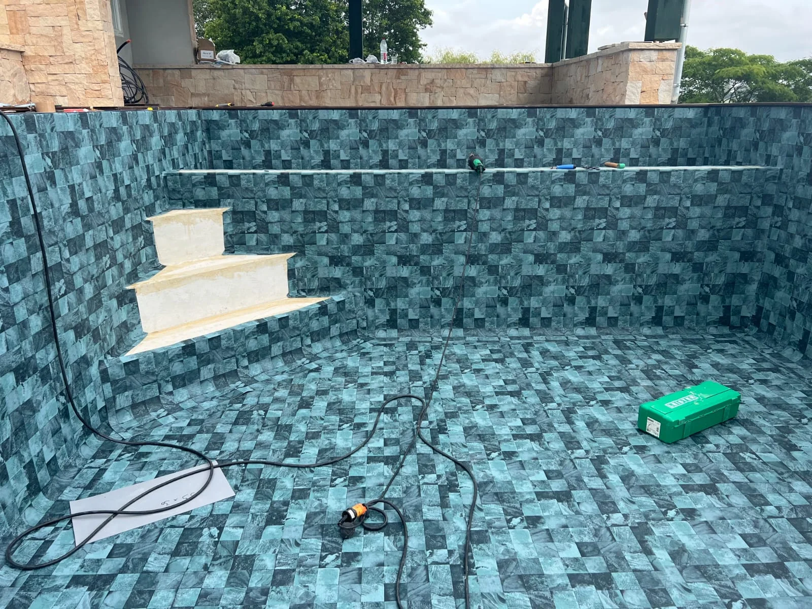 Escalier et revêtement de piscine en cours de pose