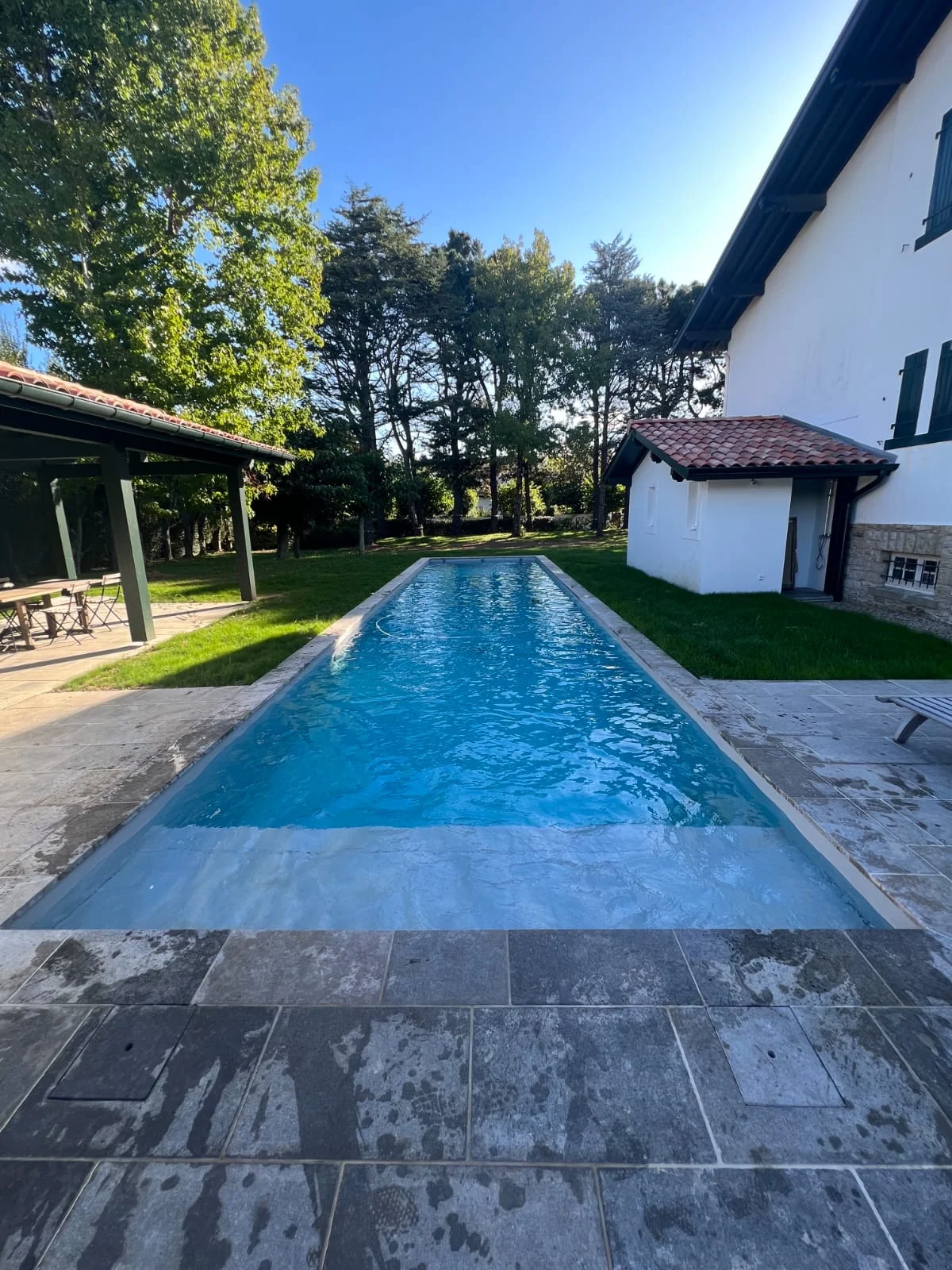 Piscine rectangulaire entre jardin et maison