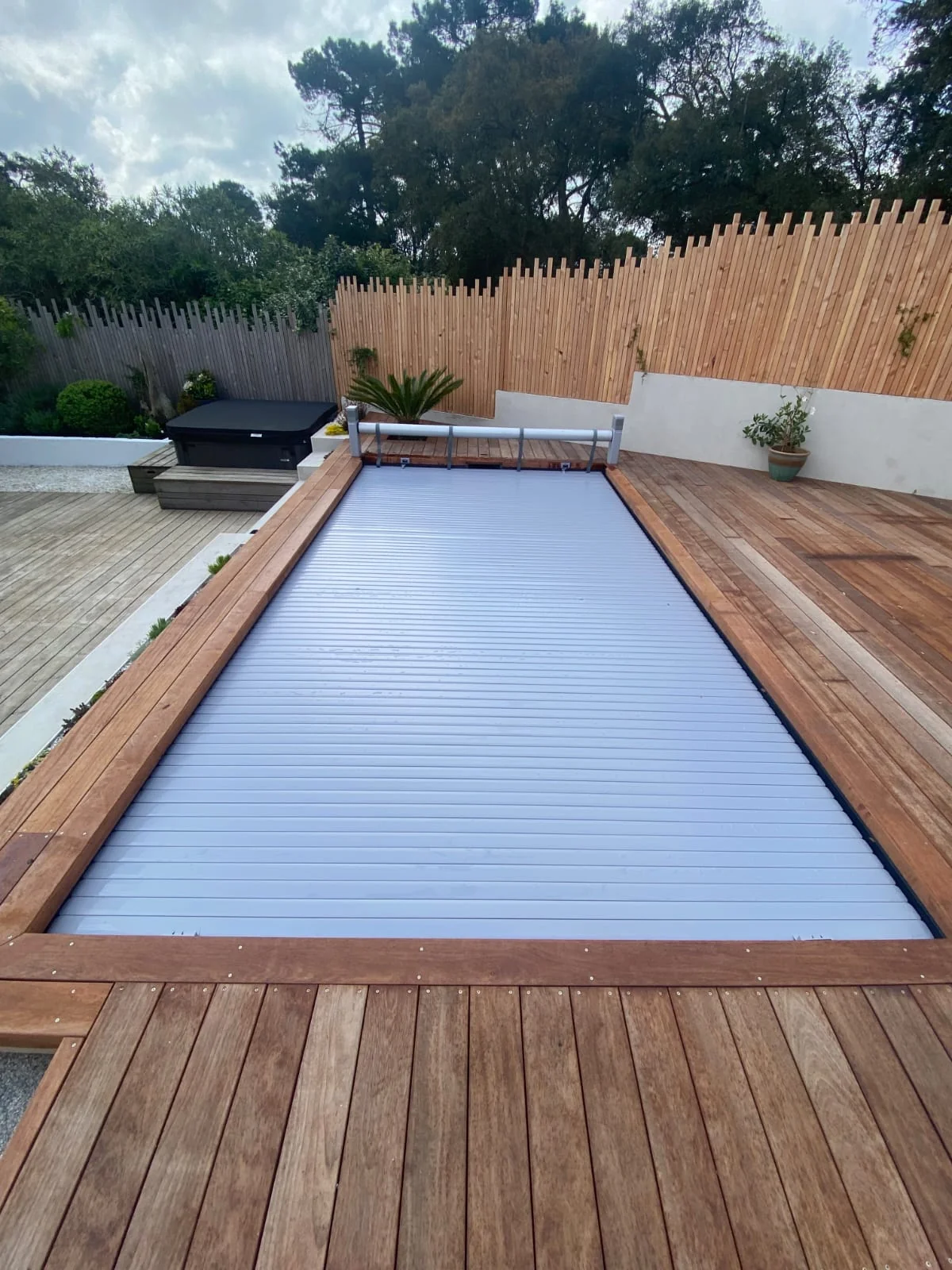 Volet de piscine fermé entre les plages en bois