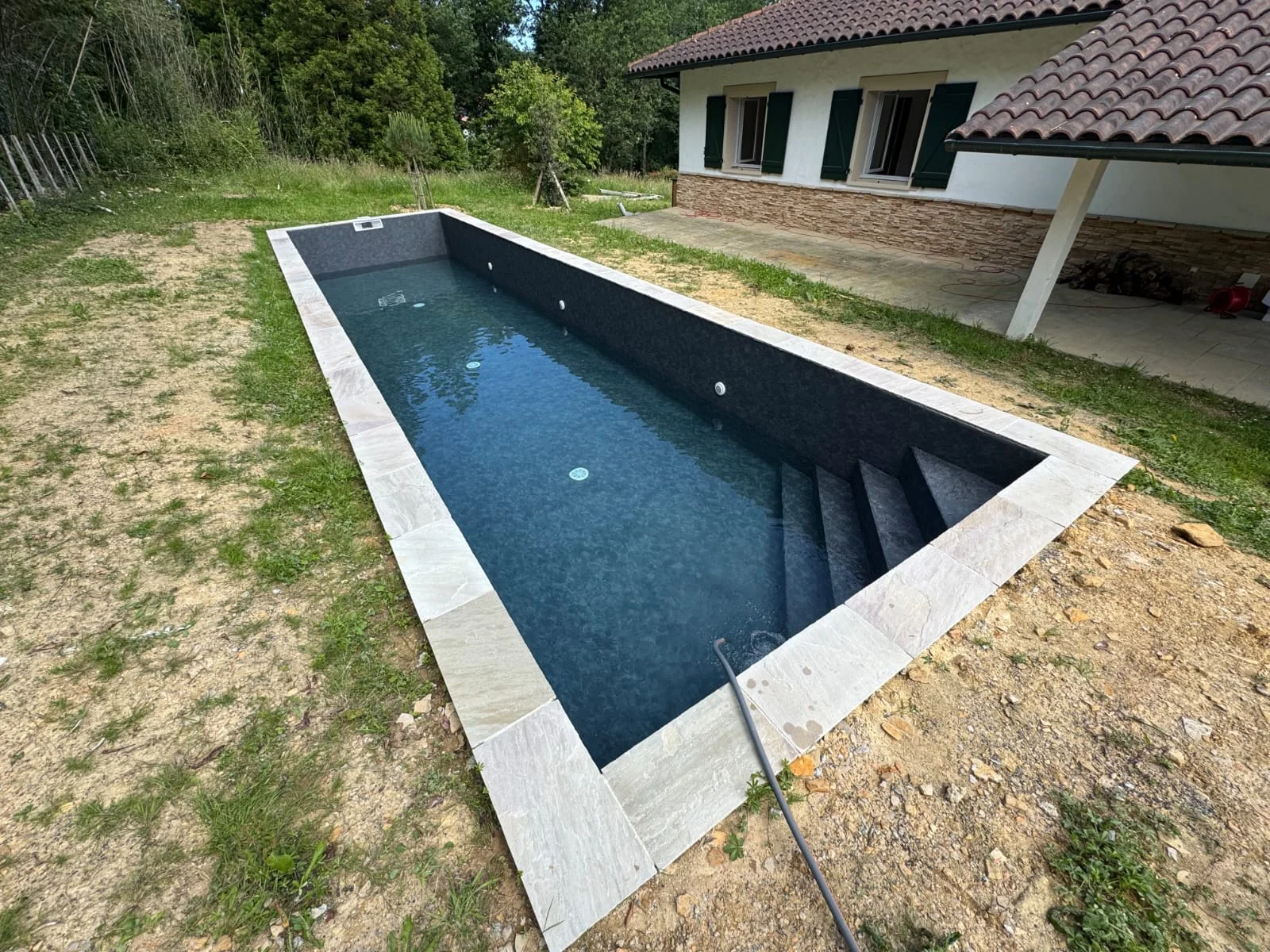 Membrane sombre et escalier d’un bassin rectangulaire avant sa mise en eau