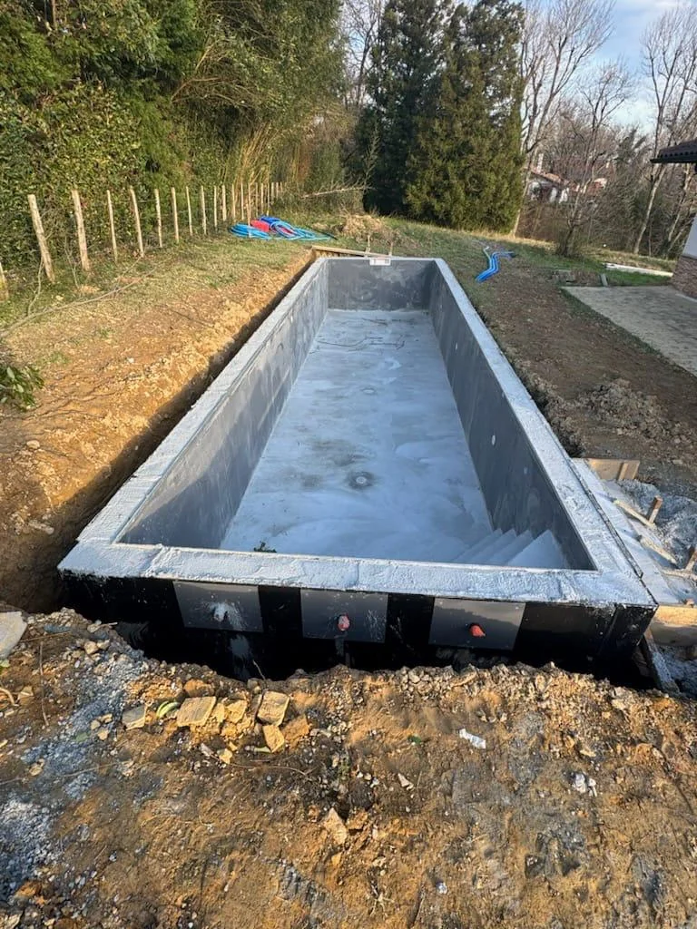 Structure rectangulaire de piscine béton avant les finitions et la mise en eau
