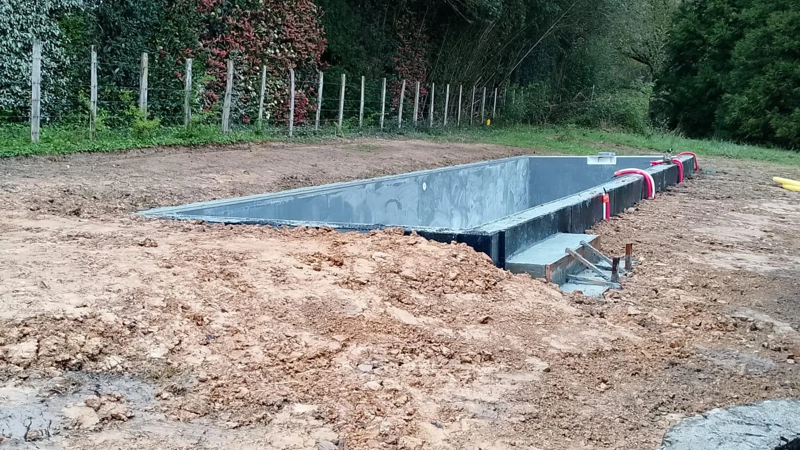 Structure de piscine en cours de réalisation sur un terrain terrassé