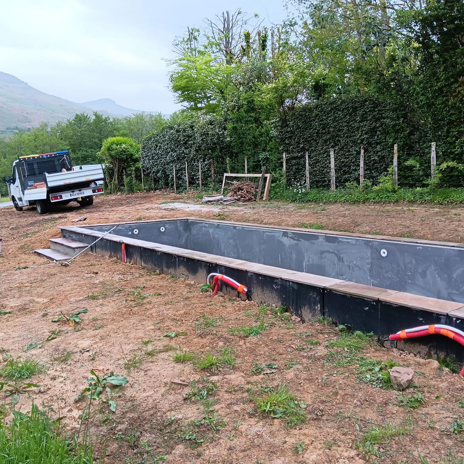 Chantier de piscine avec structure en place et paysage de montagne