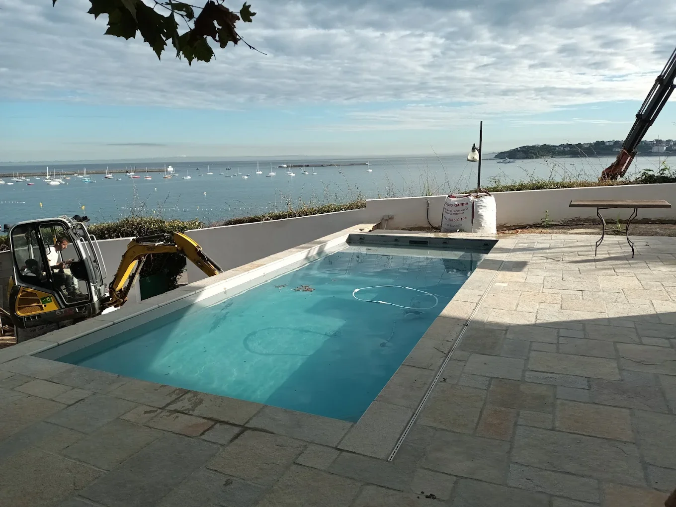 Bassin en eau près d’une terrasse avec vue sur le littoral